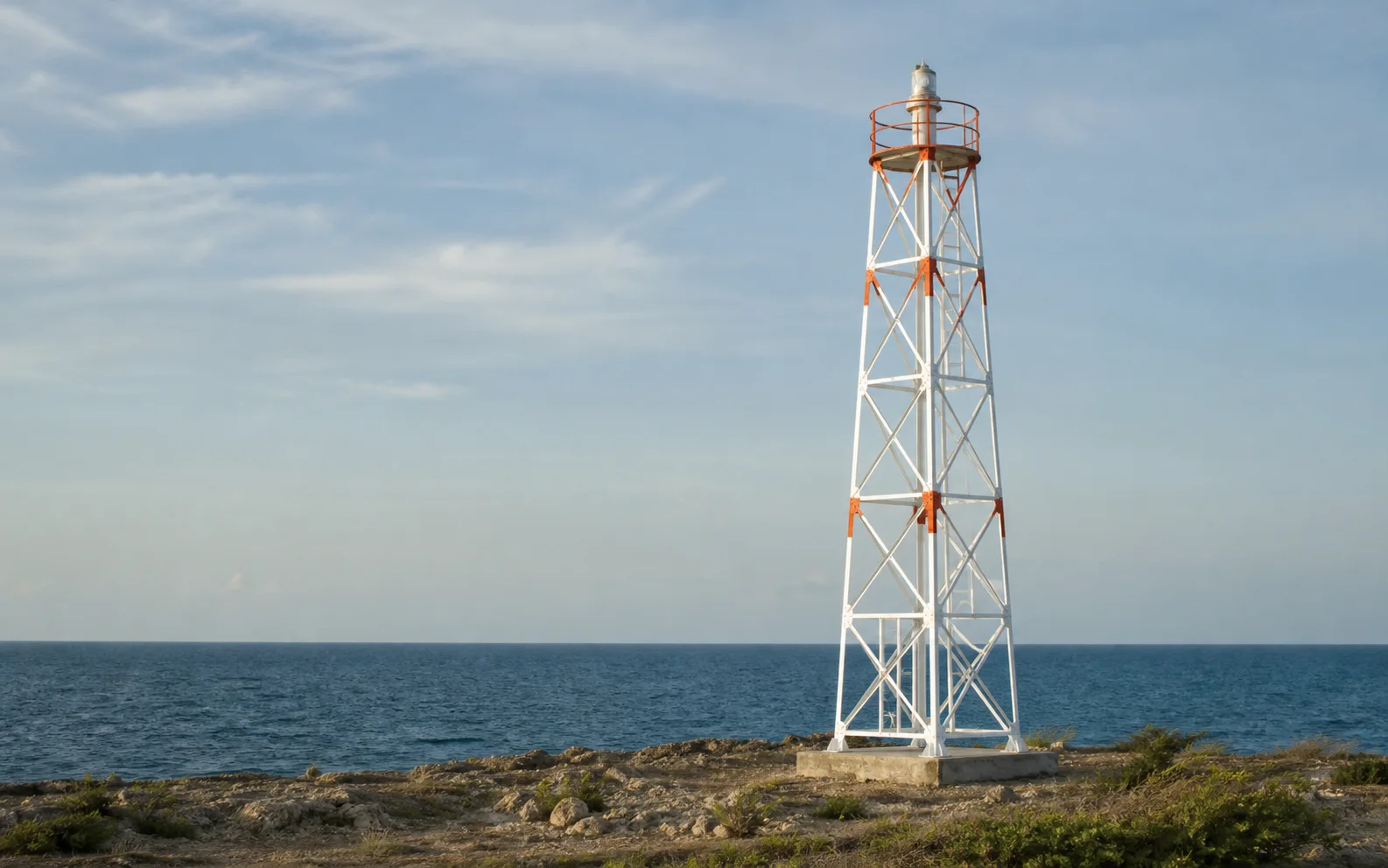 Torre metálica de señalización marítima completa sobre una costa, visual de referencia generado